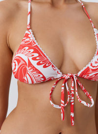 Red and white patterned bikini top on a plain background